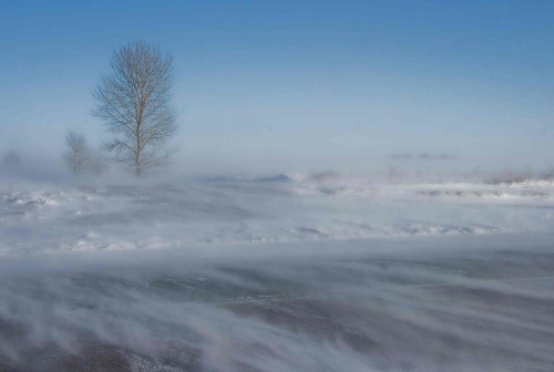 De wind doet een bestaande sneeuwlaag driften.